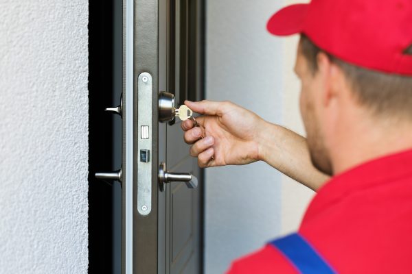 door lock service - locksmith working in red uniform